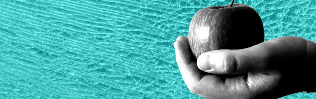 Black and white image of a hand holding an apple on background of shattered blue glass